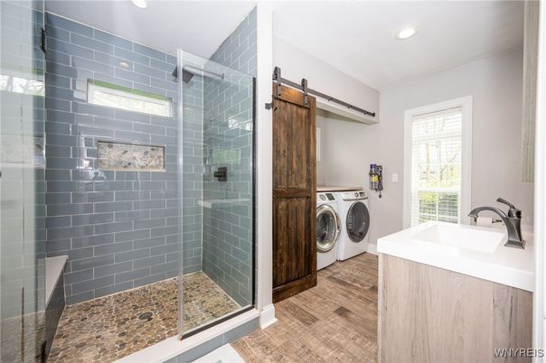 Bathroom, Glass Shower, Interior, Recessed Lighting, Washer, Wood Texture Flooring