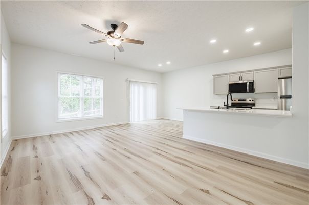 Empty room, Interior, Kitchen, Recessed Lighting, Stainless Steel Appliances, Wood Texture Flooring