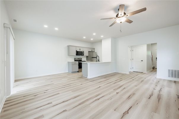 Empty room, Interior, Kitchen, Recessed Lighting, Stainless Steel Appliances, Wood Texture Flooring