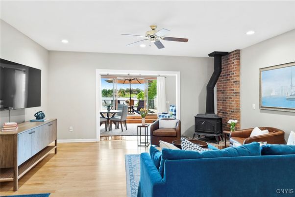 Dining room, Fireplace, Interior, Living room, Recessed Lighting, Stone Walls, Water, Wood Texture Flooring
