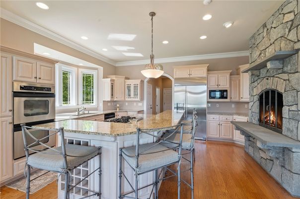 Fireplace, Interior, Kitchen, Pendant Lights, Recessed Lighting, Stainless Steel Appliances, Stone Walls, Wood Texture Flooring