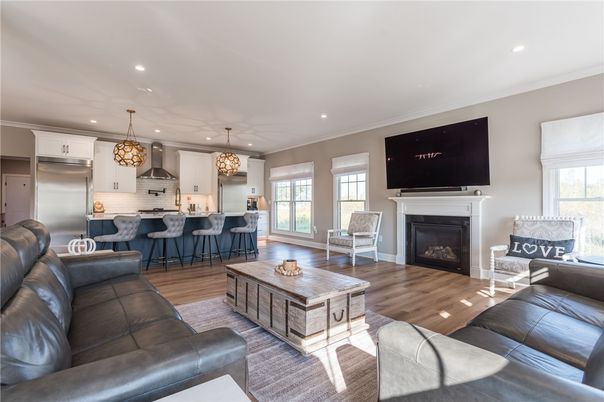 Chandelier, Fireplace, Interior, Kitchen, Living room, Pendant Lights, Recessed Lighting, Stainless Steel Appliances, Wood Texture Flooring