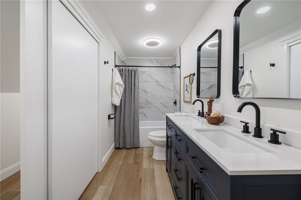 Bathroom, Dual Sink Vanities, Interior, Marble Walls, Recessed Lighting, Wood Texture Flooring