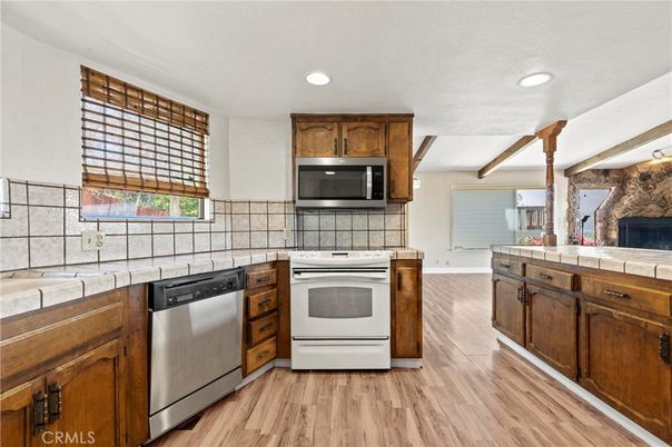 Fireplace, Interior, Kitchen, Recessed Lighting, Stainless Steel Appliances, Tile Countertops, Wood Texture Flooring