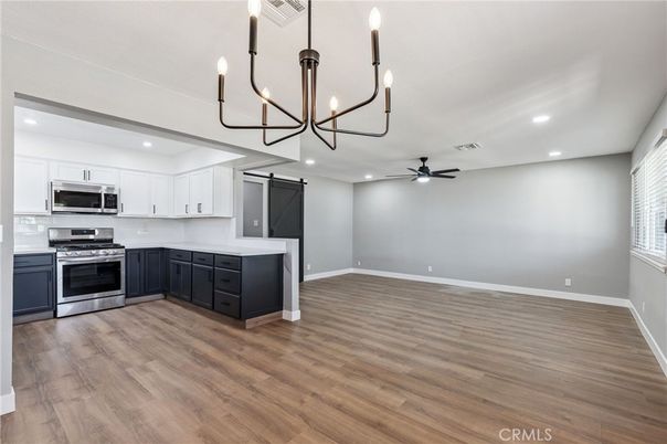 Chandelier, Empty room, Interior, Kitchen, Recessed Lighting, Stainless Steel Appliances, Wood Texture Flooring