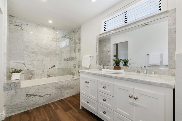 Bathroom, Dual Sink Vanities, Glass Shower, Interior, Marble Walls, Recessed Lighting, Wood Texture Flooring
