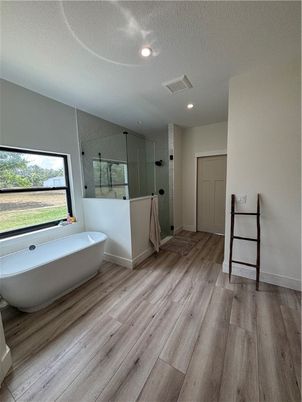 Bathroom, Free Standing Baths, Glass Shower, Interior, Recessed Lighting, Wood Texture Flooring