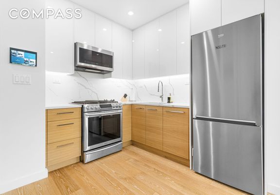 Interior, Kitchen, Marble Walls, Recessed Lighting, Stainless Steel Appliances, Wood Texture Flooring