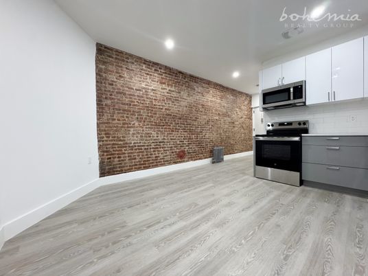 Empty room, Interior, Kitchen, Recessed Lighting, Stainless Steel Appliances, Stone Walls, Wood Texture Flooring