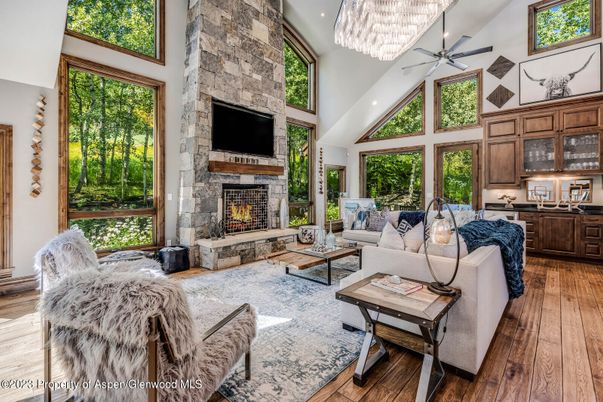 Chandelier, Fireplace, Interior, Living room, Recessed Lighting, Stone Walls, Wood Texture Flooring
