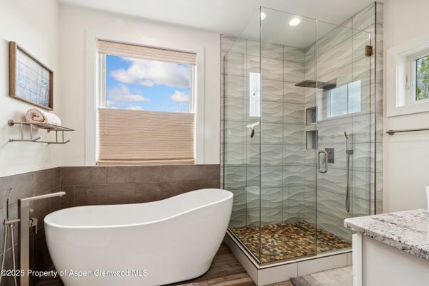 Bathroom, Free Standing Baths, Glass Shower, Interior, Marble Walls, Recessed Lighting, Wood Texture Flooring