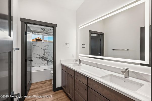 Bathroom, Dual Sink Vanities, Glass Shower, Interior, Marble Walls, Wood Texture Flooring