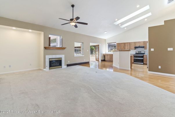 Empty room, Fireplace, Interior, Kitchen, Recessed Lighting, Stainless Steel Appliances, Wood Texture Flooring