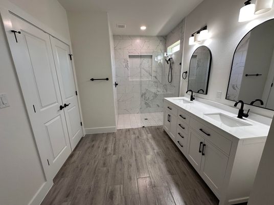 Bathroom, Dual Sink Vanities, Glass Shower, Interior, Marble Walls, Recessed Lighting, Wood Texture Flooring