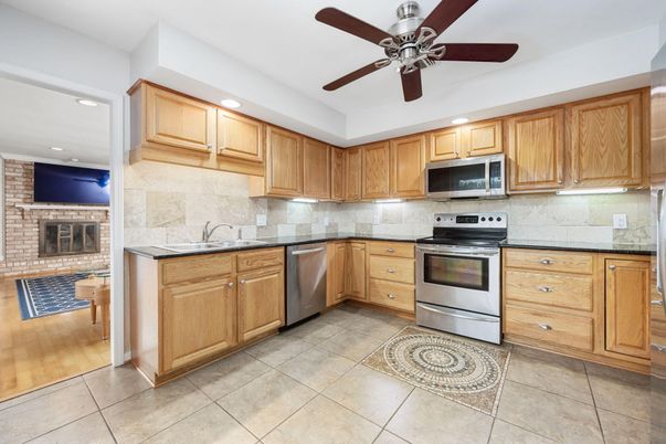 Fireplace, Interior, Kitchen, Recessed Lighting, Stainless Steel Appliances, Stone Walls