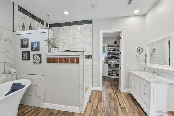 Bathroom, Dual Sink Vanities, Free Standing Baths, Interior, Marble Walls, Recessed Lighting, Walk-in Closets, Wood Texture Flooring