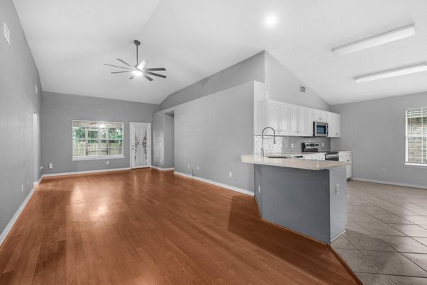 Empty room, Interior, Kitchen, Recessed Lighting, Stainless Steel Appliances, Wood Texture Flooring
