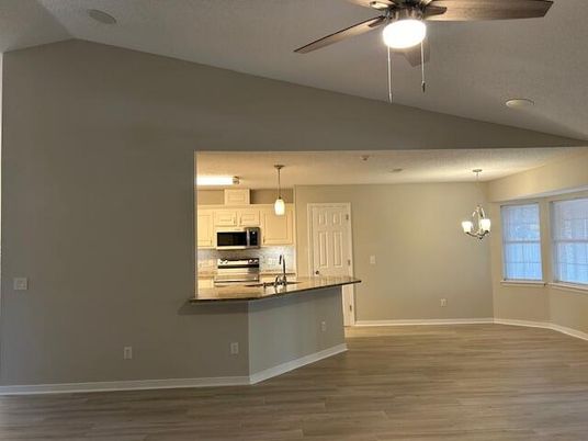 Chandelier, Empty room, Interior, Kitchen, Pendant Lights, Recessed Lighting, Stainless Steel Appliances, Wood Texture Flooring