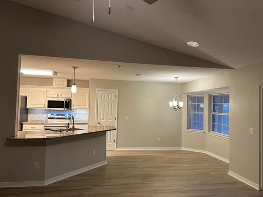 Chandelier, Empty room, Interior, Kitchen, Pendant Lights, Recessed Lighting, Stainless Steel Appliances, Wood Texture Flooring
