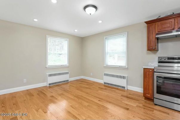 Empty room, Interior, Kitchen, Recessed Lighting, Stainless Steel Appliances, Wood Texture Flooring