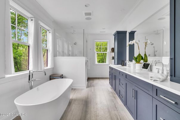 Bathroom, Dual Sink Vanities, Free Standing Baths, Glass Shower, Interior, Marble Walls, Recessed Lighting, Wood Texture Flooring