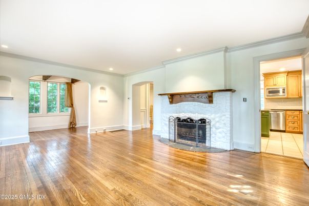 Empty room, Fireplace, Interior, Kitchen, Recessed Lighting, Stainless Steel Appliances, Wood Texture Flooring