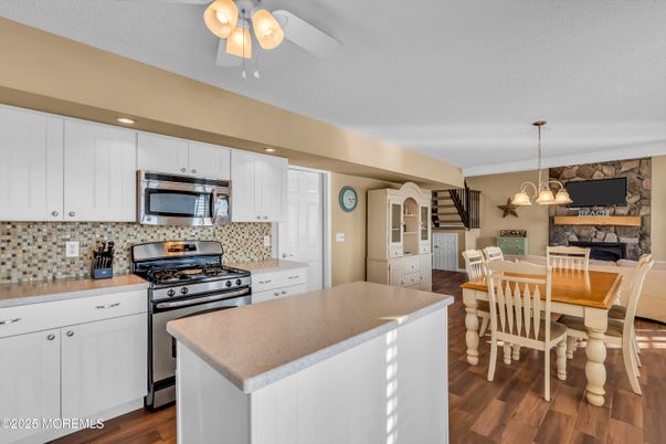 Dining room, Fireplace, Interior, Kitchen, Pendant Lights, Recessed Lighting, Stainless Steel Appliances, Stone Walls, Wood Texture Flooring