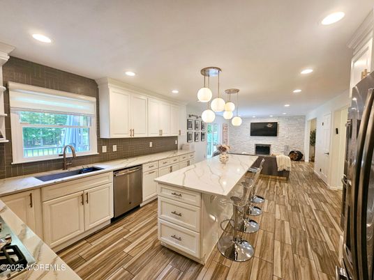 Fireplace, Interior, Kitchen, Pendant Lights, Recessed Lighting, Stainless Steel Appliances, Stone Walls, Wood Texture Flooring