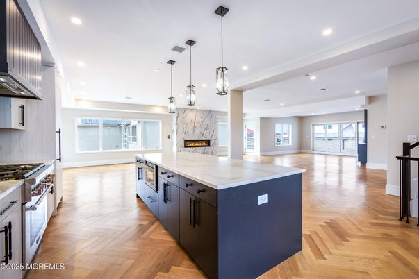 Fireplace, Interior, Kitchen, Marble Walls, Pendant Lights, Recessed Lighting, Stainless Steel Appliances, Wood Texture Flooring