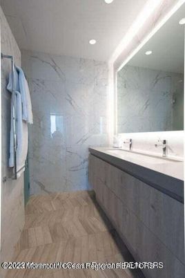 Bathroom, Dual Sink Vanities, Glass Shower, Interior, Marble Walls, Recessed Lighting, Wood Texture Flooring