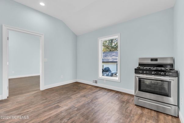 Empty room, Interior, Kitchen, Recessed Lighting, Stainless Steel Appliances, Wood Texture Flooring