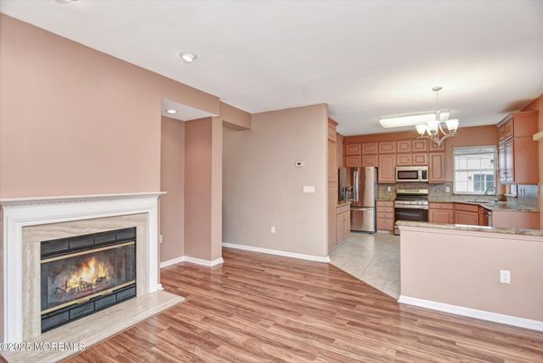 Chandelier, Fireplace, Interior, Kitchen, Recessed Lighting, Stainless Steel Appliances, Wood Texture Flooring