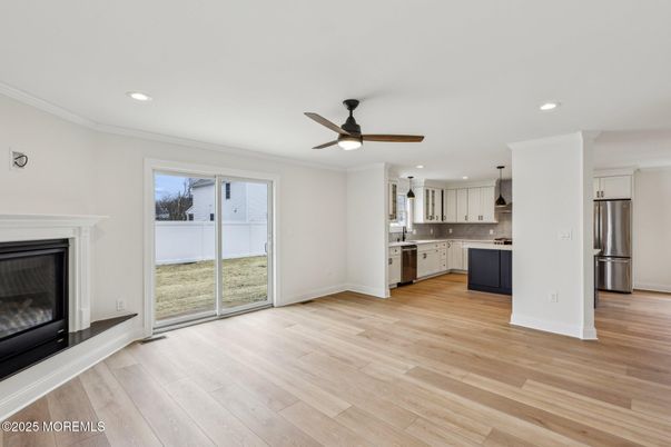 Empty room, Fireplace, Interior, Kitchen, Recessed Lighting, Stainless Steel Appliances, Wood Texture Flooring