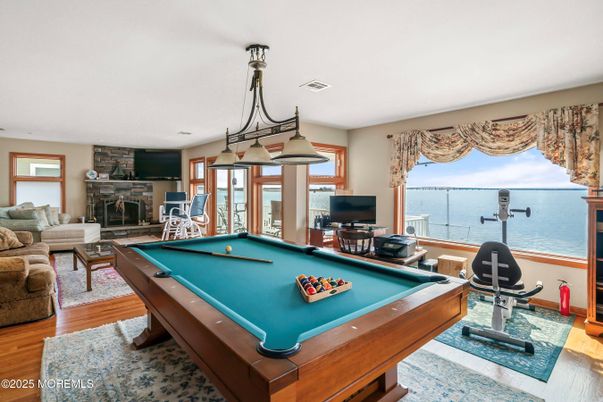 Billiard Table, Fireplace, Game Room, Interior, Living room, Stone Walls, Water, Wood Texture Flooring
