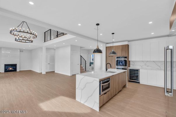 Chandelier, Fireplace, Interior, Kitchen, Pendant Lights, Recessed Lighting, Stainless Steel Appliances, Wood Texture Flooring