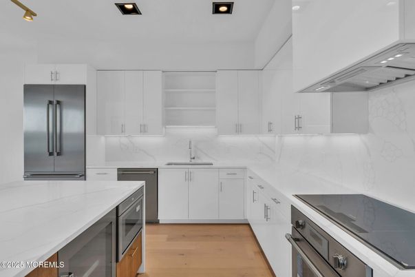Interior, Kitchen, Marble Walls, Recessed Lighting, Stainless Steel Appliances, Wood Texture Flooring