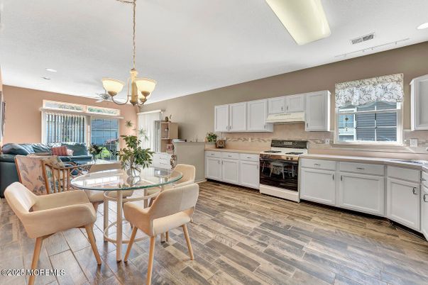 Chandelier, Dining room, Interior, Kitchen, Living room, Pendant Lights, Recessed Lighting, Stainless Steel Appliances, Wood Texture Flooring