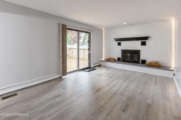 Empty room, Fireplace, Interior, Recessed Lighting, Stone Walls, Wood Texture Flooring