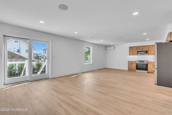 Empty room, Interior, Kitchen, Recessed Lighting, Stainless Steel Appliances, Wood Texture Flooring