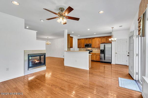 Chandelier, Empty room, Fireplace, Interior, Kitchen, Recessed Lighting, Stainless Steel Appliances, Wood Texture Flooring