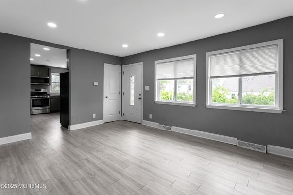 Empty room, Interior, Kitchen, Recessed Lighting, Stainless Steel Appliances, Wood Texture Flooring