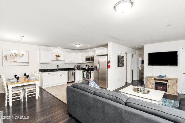 Chandelier, Dining room, Fireplace, Interior, Kitchen, Living room, Recessed Lighting, Stainless Steel Appliances, Wood Texture Flooring