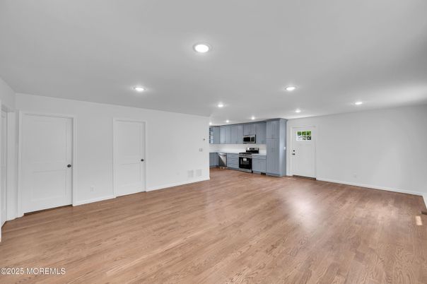 Empty room, Interior, Kitchen, Recessed Lighting, Stainless Steel Appliances, Wood Texture Flooring