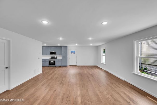 Empty room, Interior, Kitchen, Recessed Lighting, Stainless Steel Appliances, Wood Texture Flooring