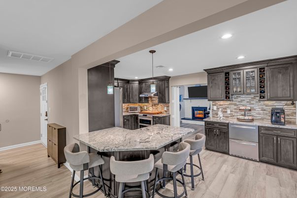 Fireplace, Interior, Kitchen, Pendant Lights, Recessed Lighting, Stainless Steel Appliances, Stone Walls, Wood Texture Flooring