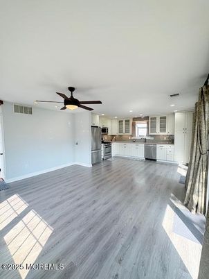 Empty room, Interior, Kitchen, Recessed Lighting, Stainless Steel Appliances, Wood Texture Flooring