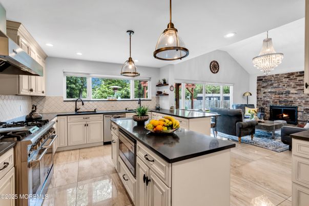 Chandelier, Fireplace, Interior, Kitchen, Living room, Pendant Lights, Recessed Lighting, Stainless Steel Appliances, Stone Walls