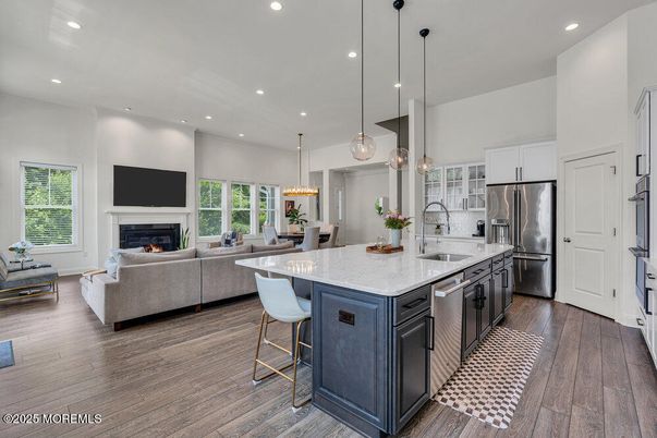 Chandelier, Dining room, Fireplace, Interior, Kitchen, Living room, Pendant Lights, Recessed Lighting, Stainless Steel Appliances, Wood Texture Flooring