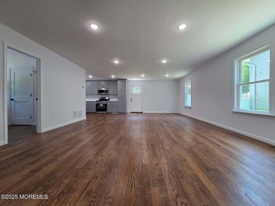 Empty room, Interior, Kitchen, Recessed Lighting, Stainless Steel Appliances, Wood Texture Flooring
