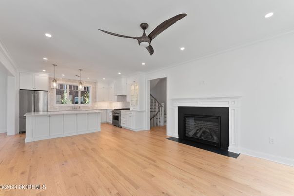 Empty room, Fireplace, Interior, Kitchen, Pendant Lights, Recessed Lighting, Stainless Steel Appliances, Wood Texture Flooring
